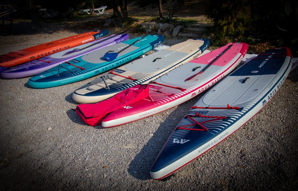 Deski sup Aqua Mariny leżące na plaży